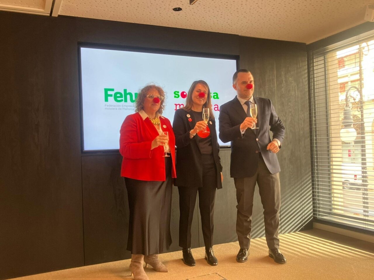 Tres personas con nariz de payaso celebrando una recaudaci&oacute;n ben&eacute;fica