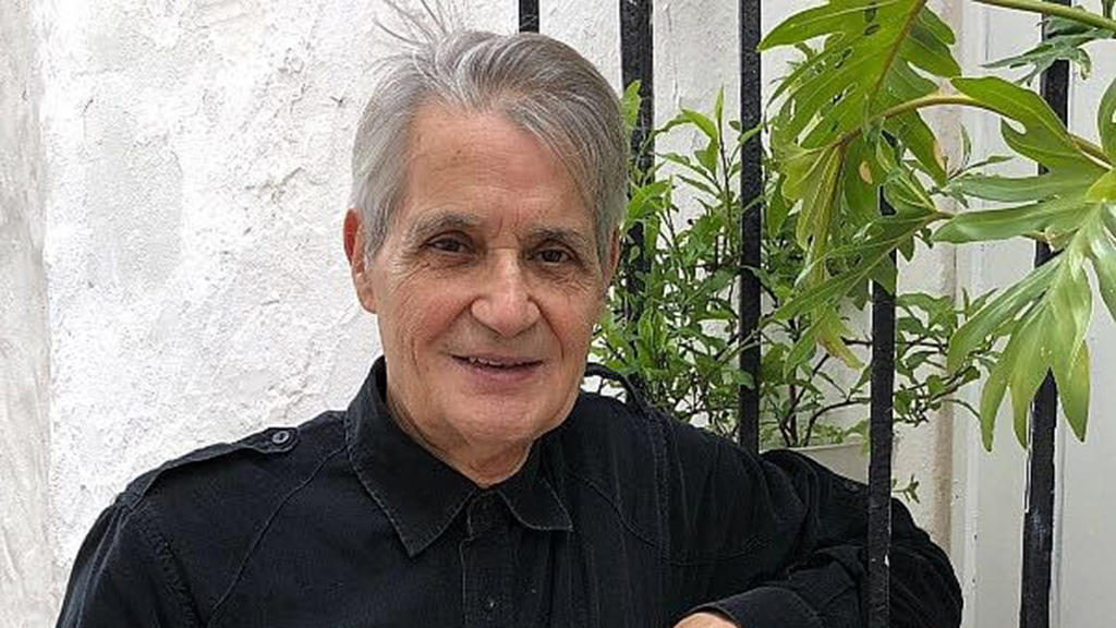 Felipe Campuzano posando con fondo de plantas verdes