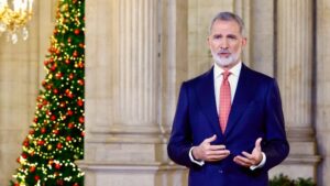 Felipe VI pronunciando su discurso navide&ntilde;o en el Palacio Real con un &aacute;rbol decorado detr&aacute;s.