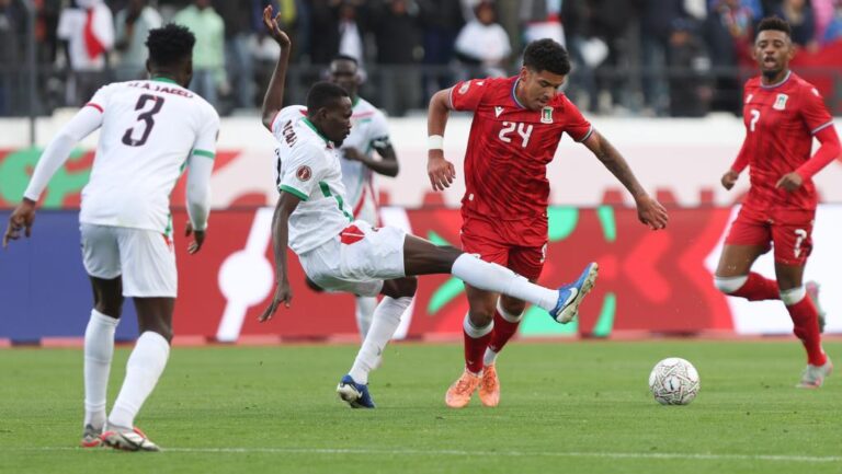Jugadores de Guinea y Sudán compiten en un partido de fútbol