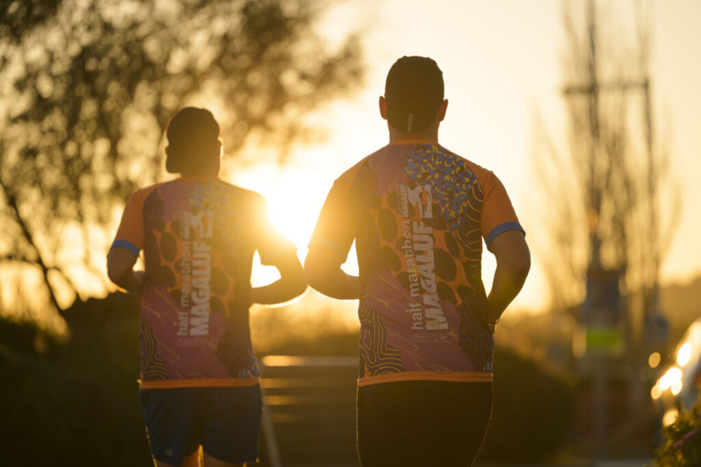 Corredores de espaldas en la Half Marathon Magaluf al atardecer