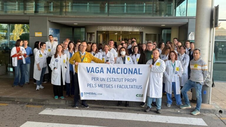 Médicos en huelga sosteniendo un cartel en la entrada de un hospital