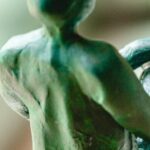 Escultura de cerámica que representa una figura humana abrazando a un niño.