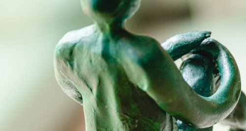 Escultura de cerámica que representa una figura humana abrazando a un niño.