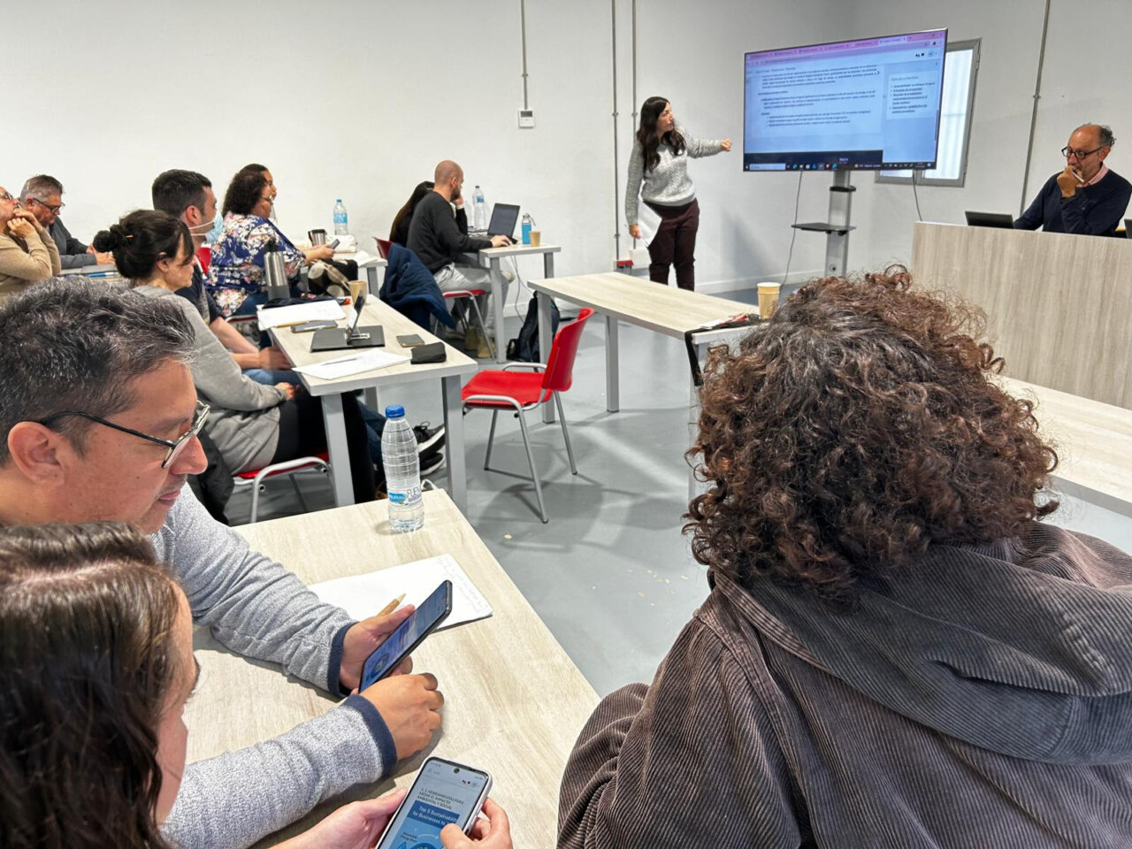Alumnos de FP Dual en un aula utilizando dispositivos m&oacute;viles durante la presentaci&oacute;n