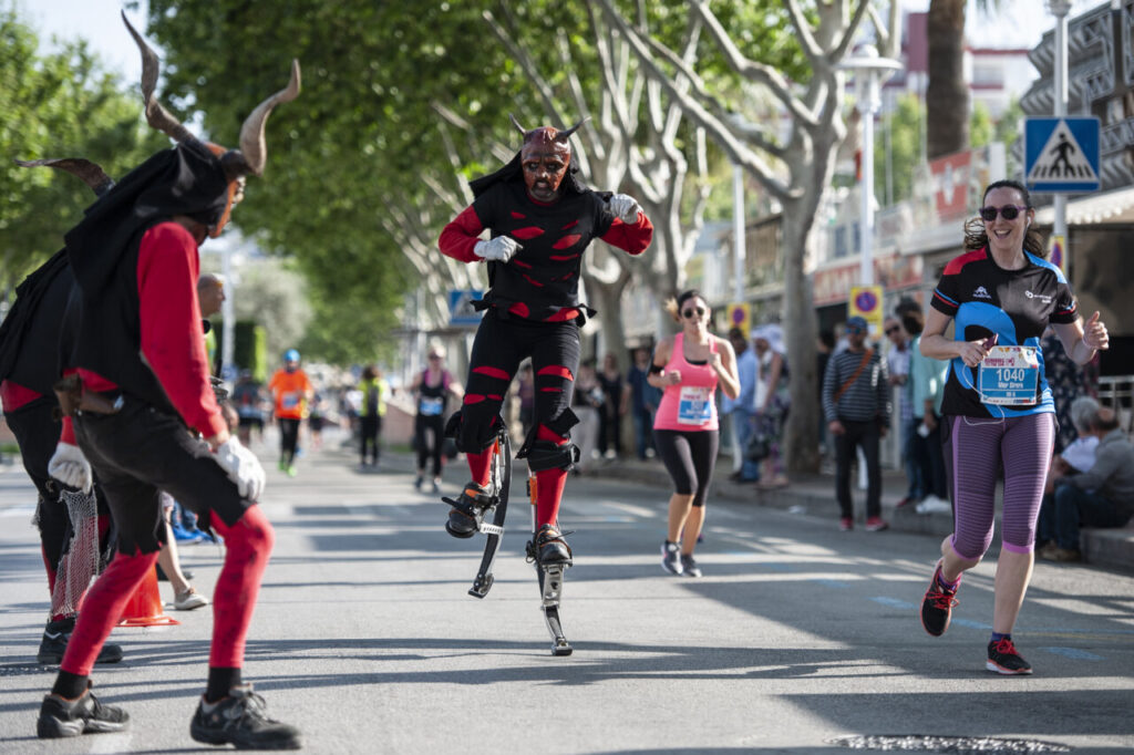 Corredores en la Half Marathon Magaluf 2026 con animación en la calle.