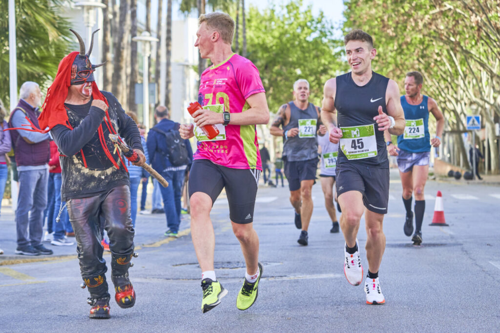 Corredores en la Half Marathon de Magaluf con un animador disfrazado