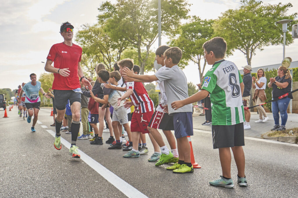 Corredores en la Half Marathon Magaluf 2026 con niños animando.