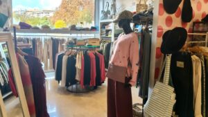 Interior de la tienda Mamy Poppins con ropa y accesorios variados