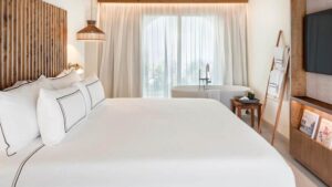 Habitaci&oacute;n de hotel con cama blanca y decoraci&oacute;n moderna