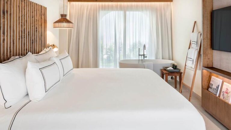 Habitación de hotel con cama blanca y decoración moderna