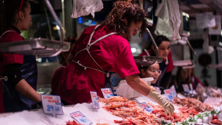 Vendedora en el Mercado del Olivar seleccionando marisco fresco