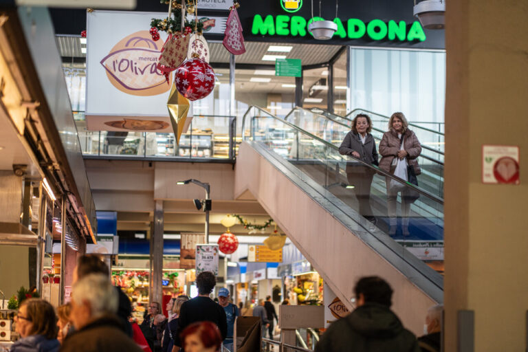 Interior del Mercado del Olivar decorado para Navidad con gente comprando.