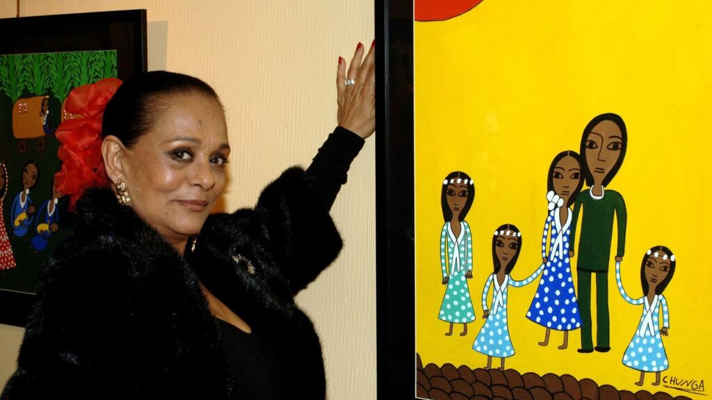 Micaela Flores Amaya, conocida como La Chunga, posando junto a una pintura