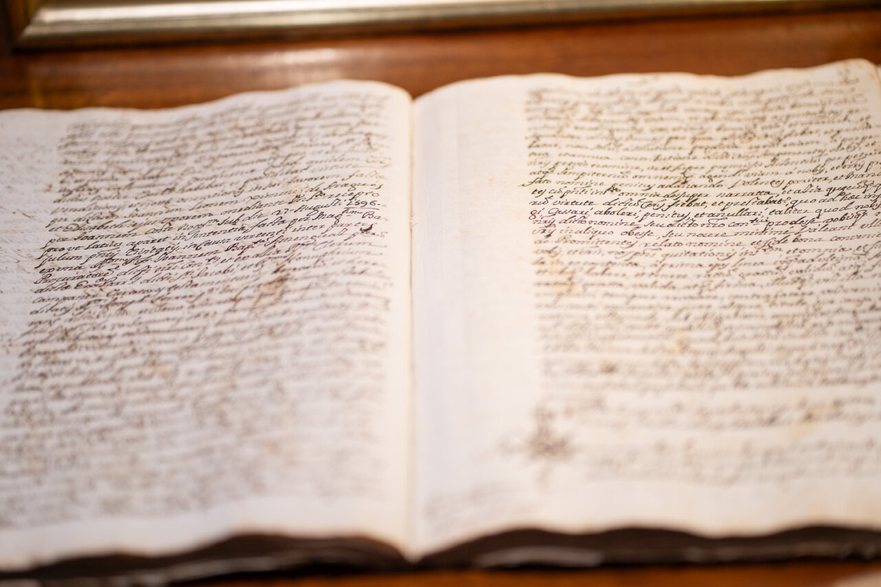 Libro antiguo abierto con escritura manuscrita en páginas amarillentas.