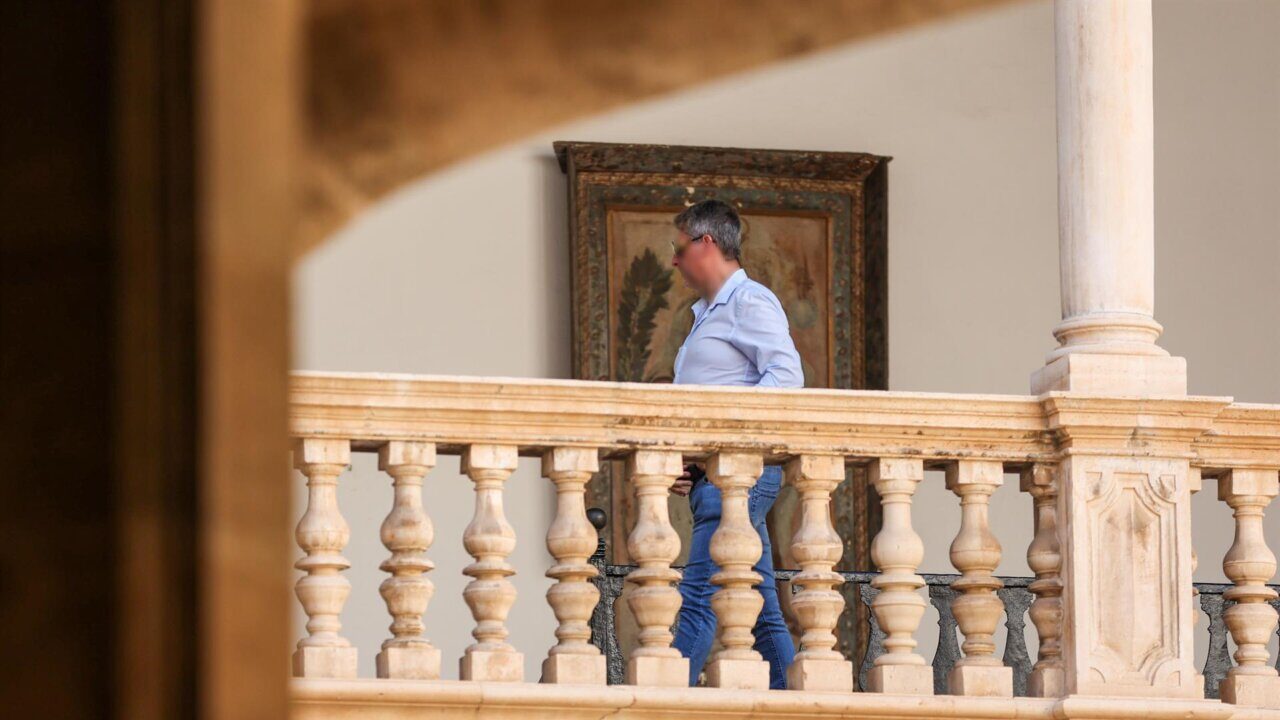 Persona caminando en un balc&oacute;n con barandilla decorativa.