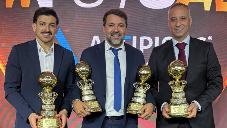 Tres premiados sosteniendo trofeos en la gala de los Premios Mundo do Futsal.