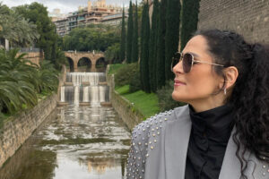 Mujer con gafas de sol junto a una cascada en un parque