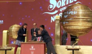 Participantes en el sorteo de la loter&iacute;a con un gran globo dorado