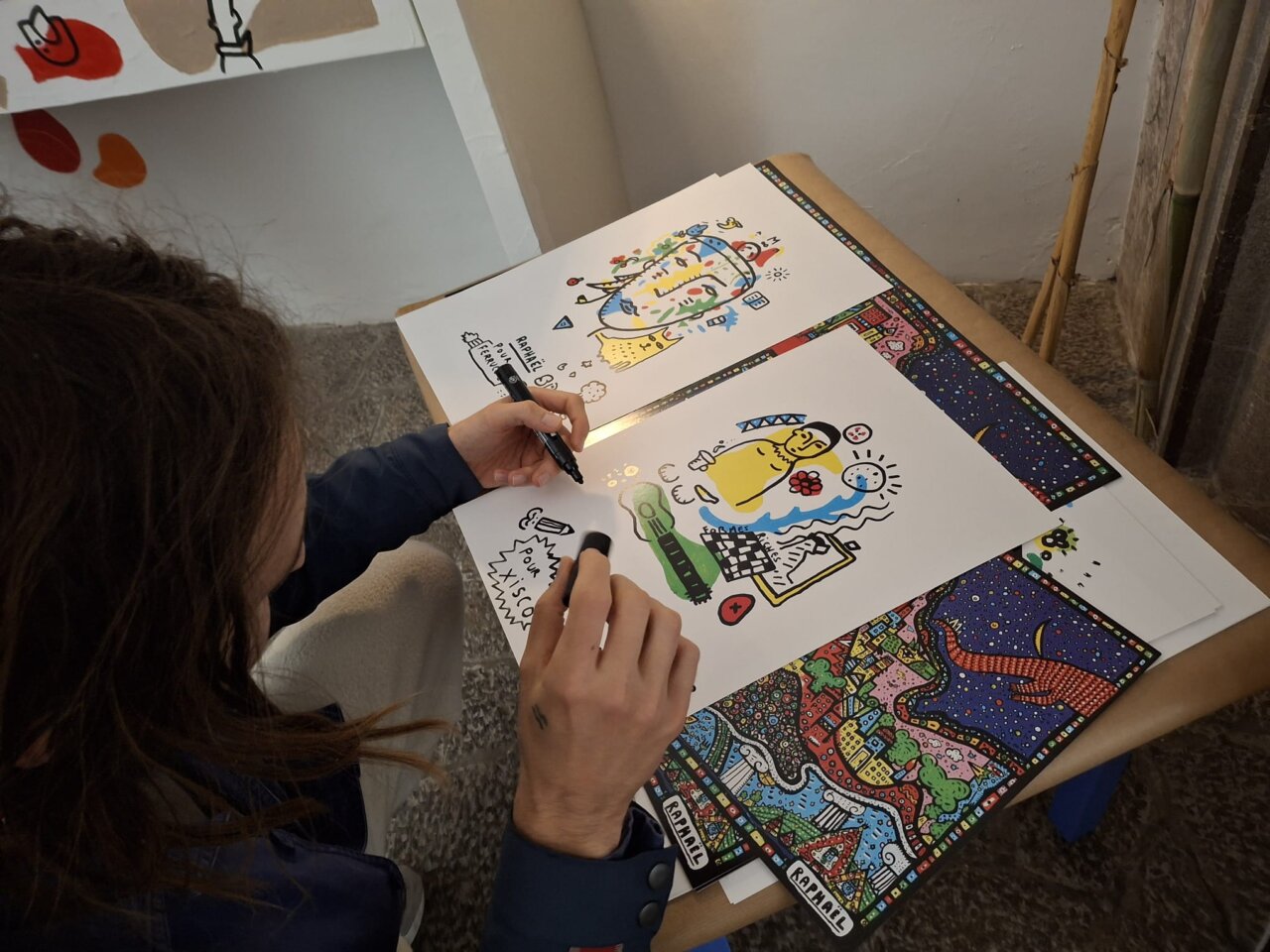Artista Space Rapha&euml;l creando una obra con marcadores