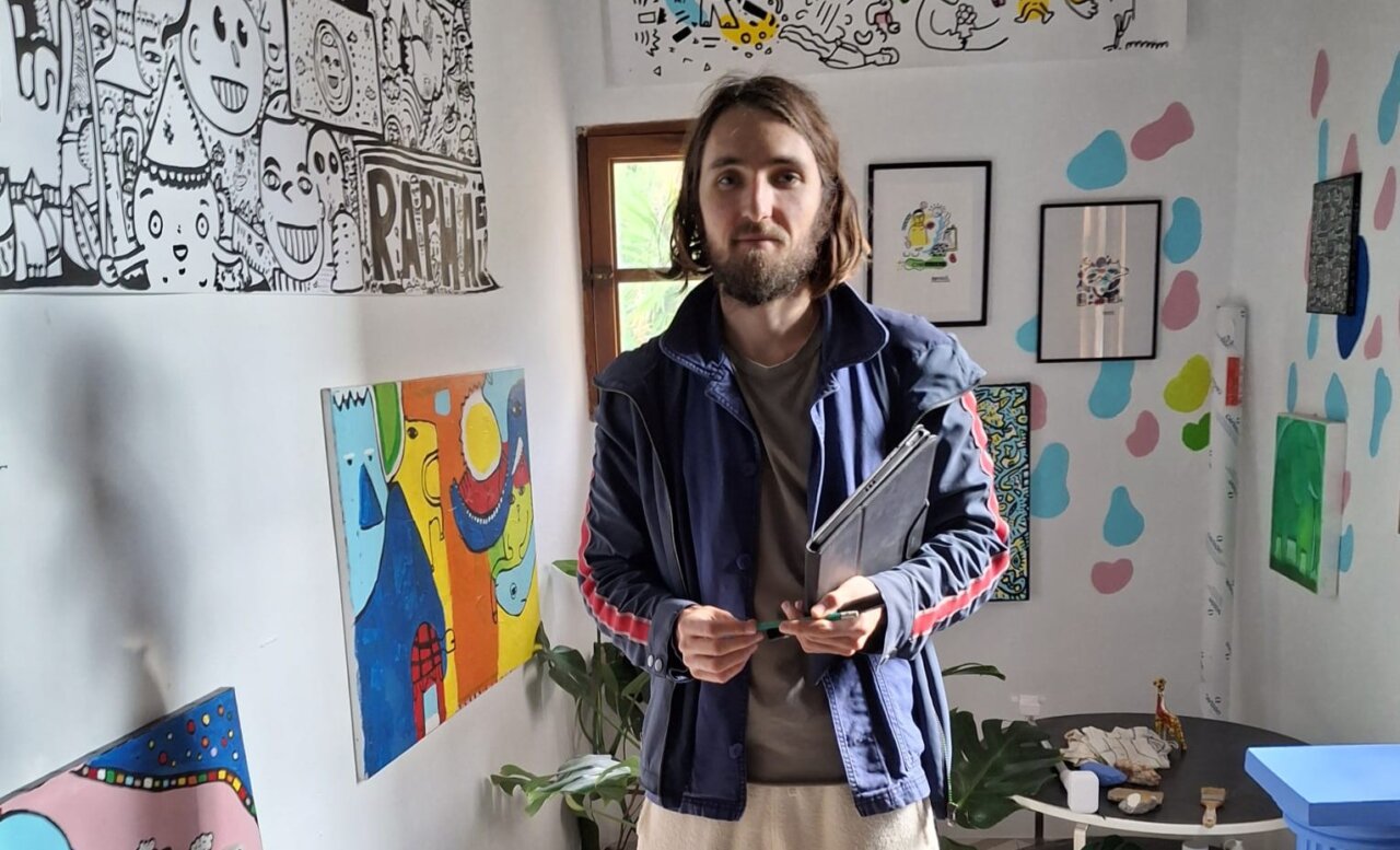 Space Rapha&euml;l en su taller rodeado de arte colorido