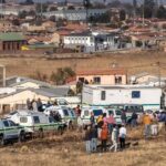 Escena del tiroteo en Bekkersdal, Sud&aacute;frica, con presencia policial.