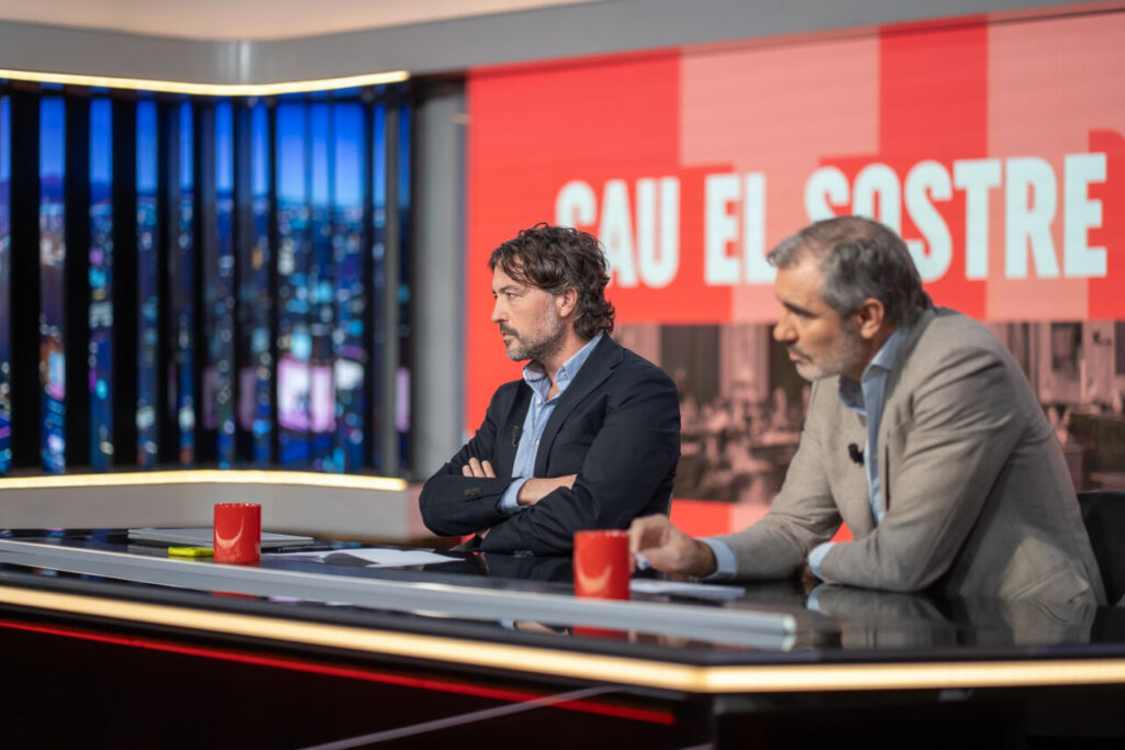 Dos hombres en un set de televisión discutiendo en un programa.