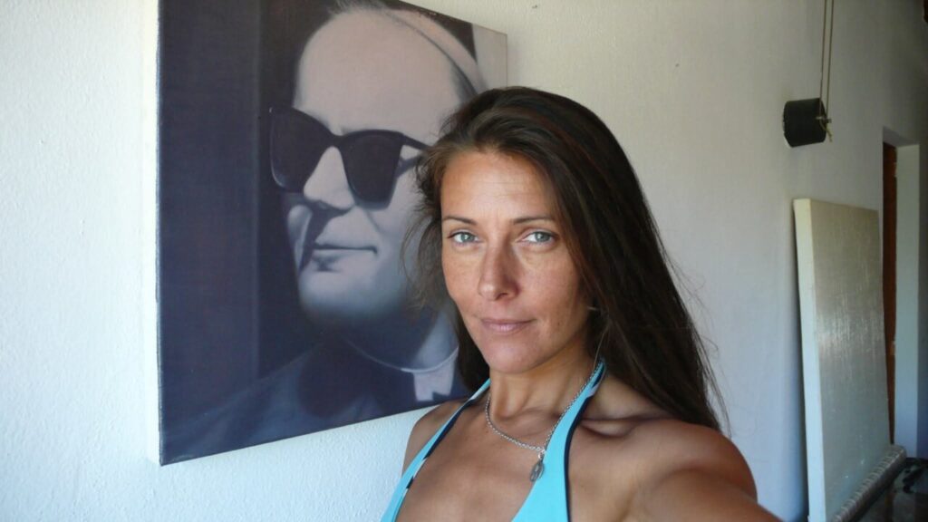 Silvina Barrera posando frente a un retrato en una terraza