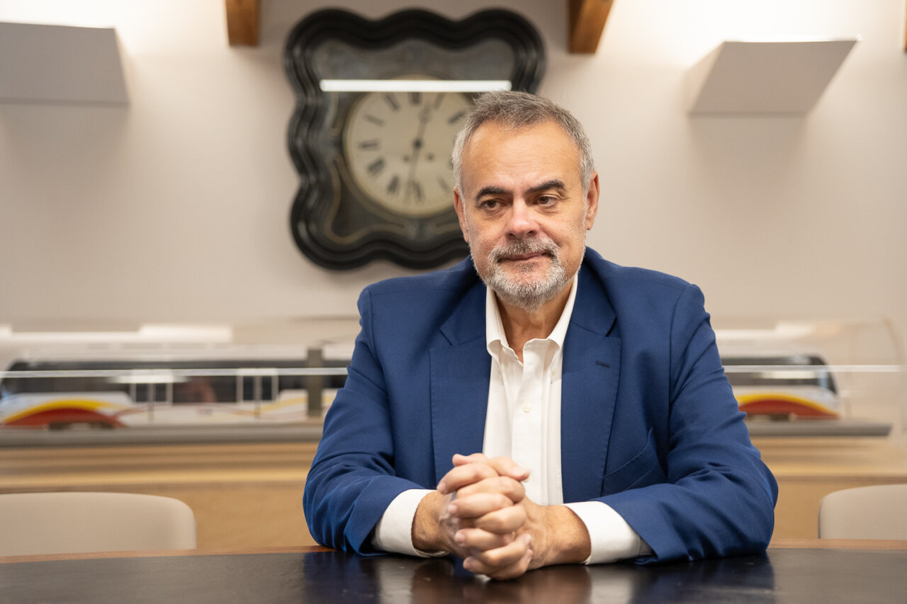 José Ramon Orta sentado en una mesa con reloj de fondo