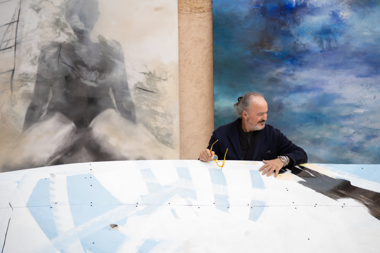 Luca Monzani trabajando en su exposición 'Héroes' con obras de fondo