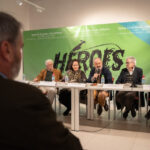 Mesa redonda sobre h&eacute;roes con varios ponentes en un evento cultural.
