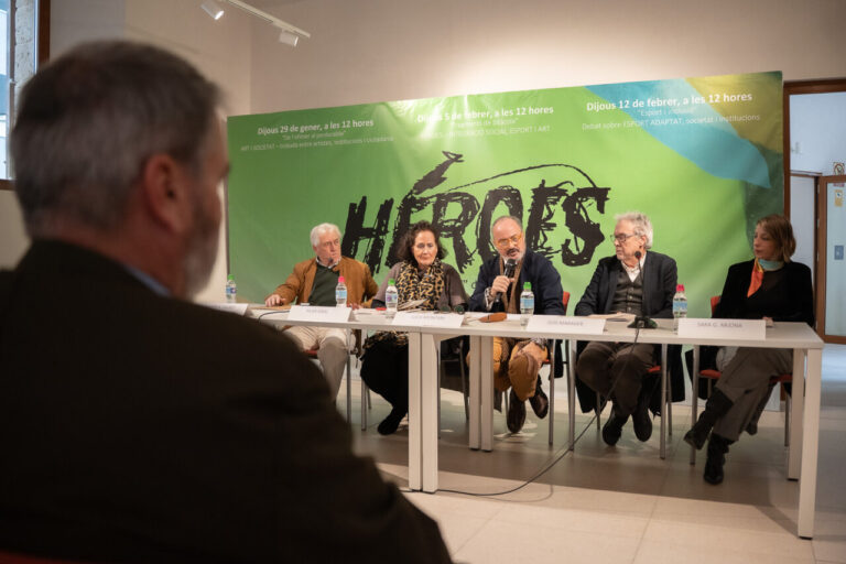 Mesa redonda sobre h&eacute;roes con varios ponentes en un evento cultural.