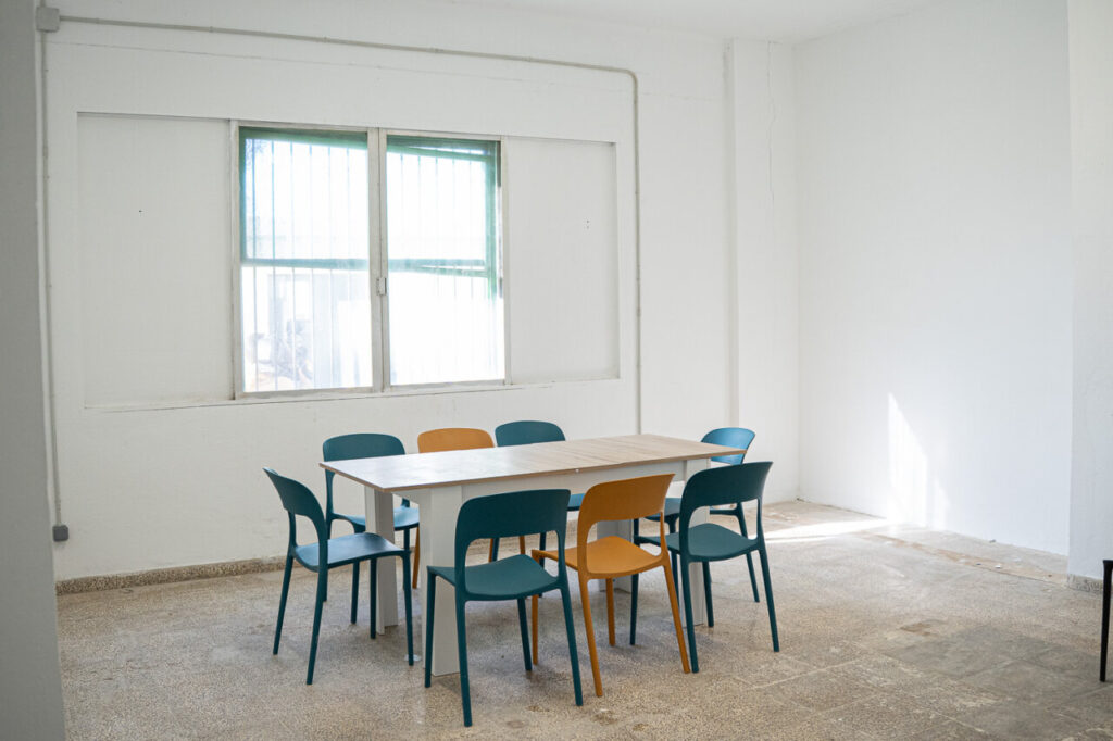 Sala con mesa y sillas en un centro de acogida para migrantes