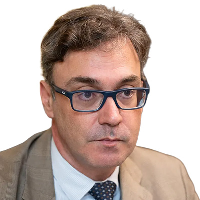 Retrato de Toni Costa con gafas y traje claro