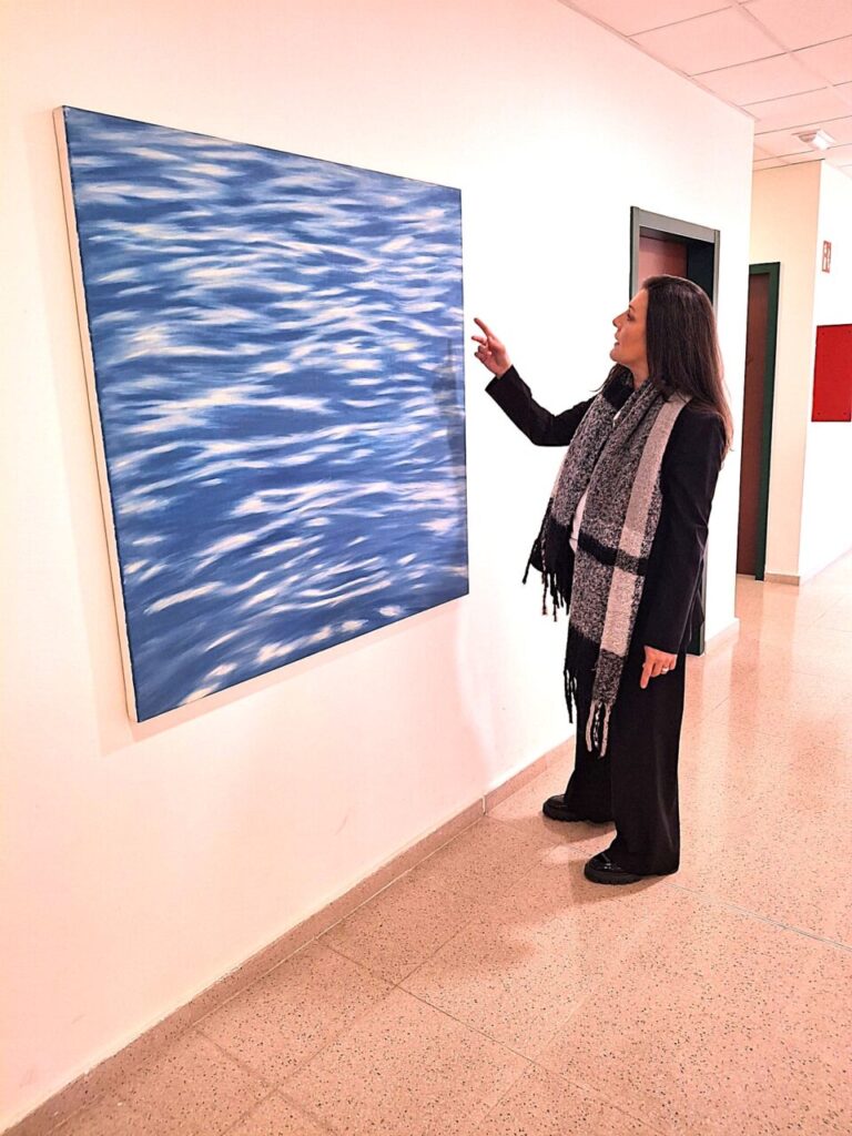 Silvina Barrera se&ntilde;alando una pintura en una galer&iacute;a