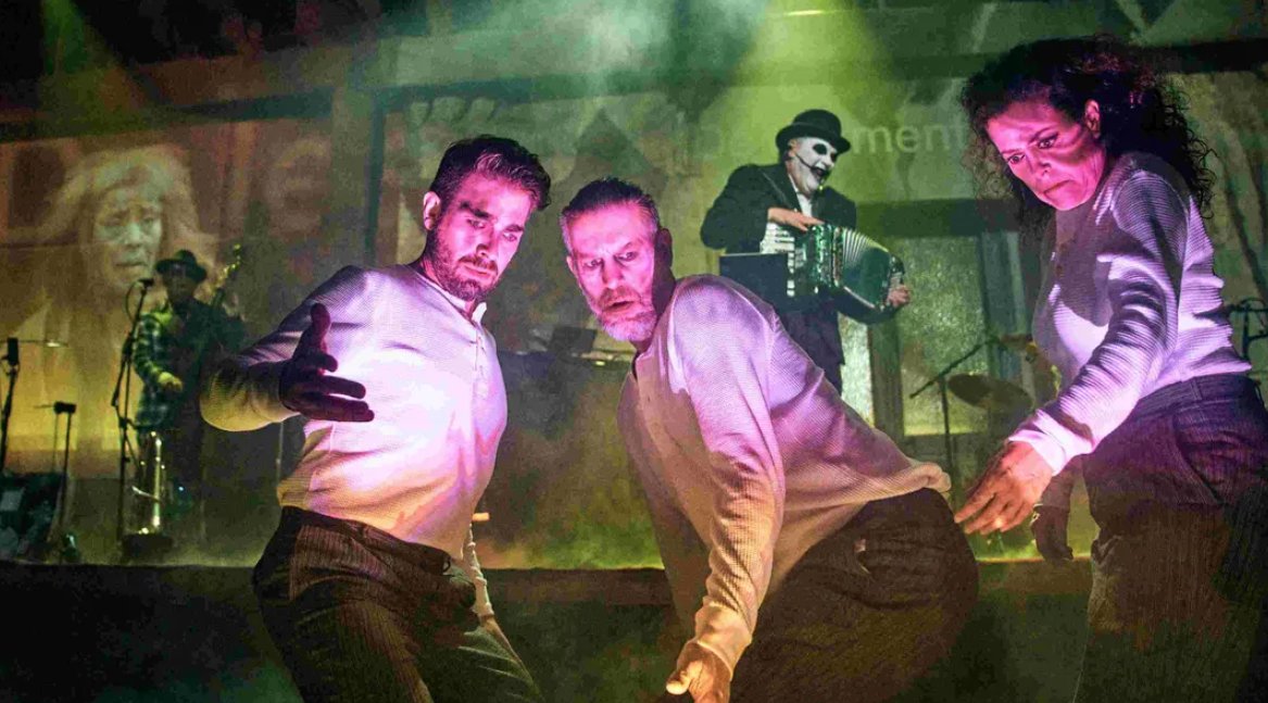 Actuación teatral con tres bailarines en un escenario iluminado