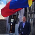 Agust&iacute;n Rodr&iacute;guez posando frente a la embajada de Venezuela con la bandera