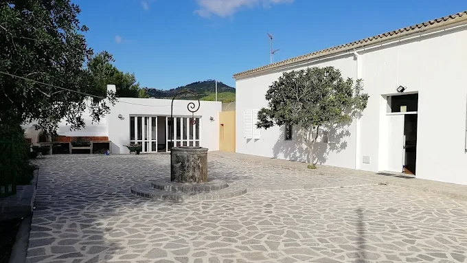 Vista del Camp d&rsquo;Aprenentatge en Sant Joan de Labritja con un pozo y vegetaci&oacute;n
