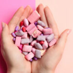 Manos sosteniendo una variedad de chicles de colores