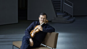 Violinista Frank Peter Zimmermann posando con su viol&iacute;n en un escenario