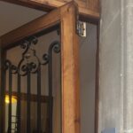 Puerta de acceso a una comunidad con da&ntilde;os visibles tras un incidente.