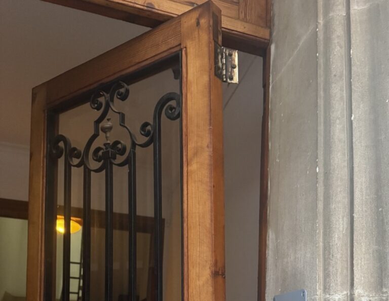 Puerta de acceso a una comunidad con daños visibles tras un incidente.