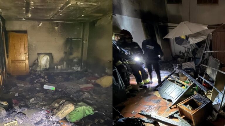 Habitaci&oacute;n afectada por incendio con escombros y humo visible
