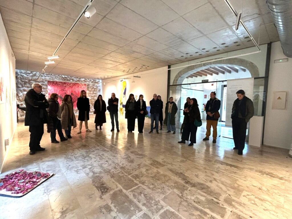 Visita a la exposici&oacute;n de la University Art Biennial en Alar&oacute; con varias personas observando las obras.