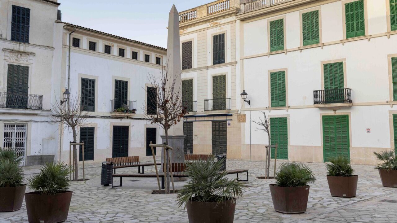 Plaza en Felanitx con edificios y vegetaci&oacute;n en macetas.