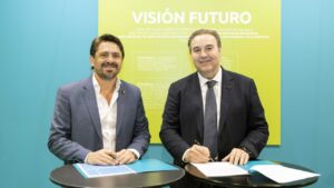 Dos hombres firmando un convenio en un evento de turismo