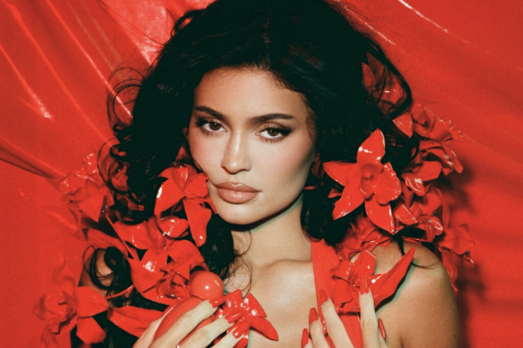 Kylie Jenner con flores rojas en un fondo vibrante