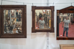 Hombre caminando entre espejos en un mercadillo de Navidad