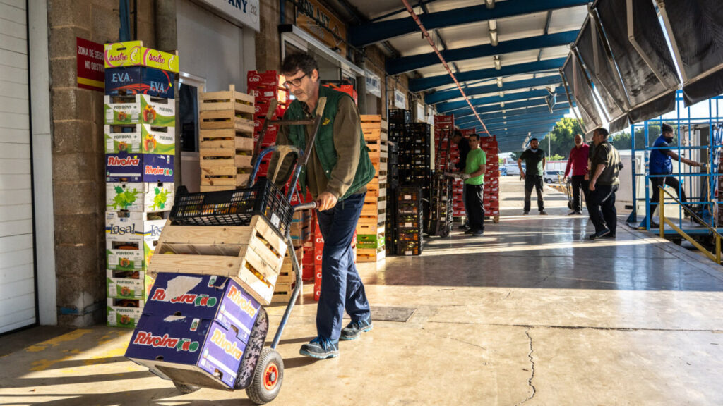 Hombre transportando cajas en un mercado de Palma durante la pandemia