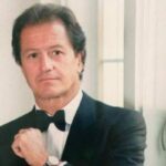 Phillippe Junot posando con traje formal y corbata negra